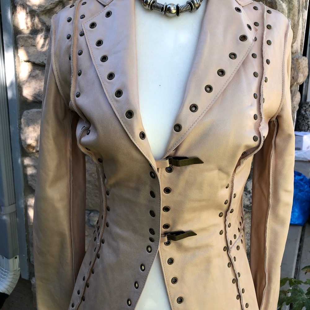 Very light pink leather jacket with studs and grommets